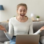 Excited woman looking at laptop screen, receiving good unexpected news